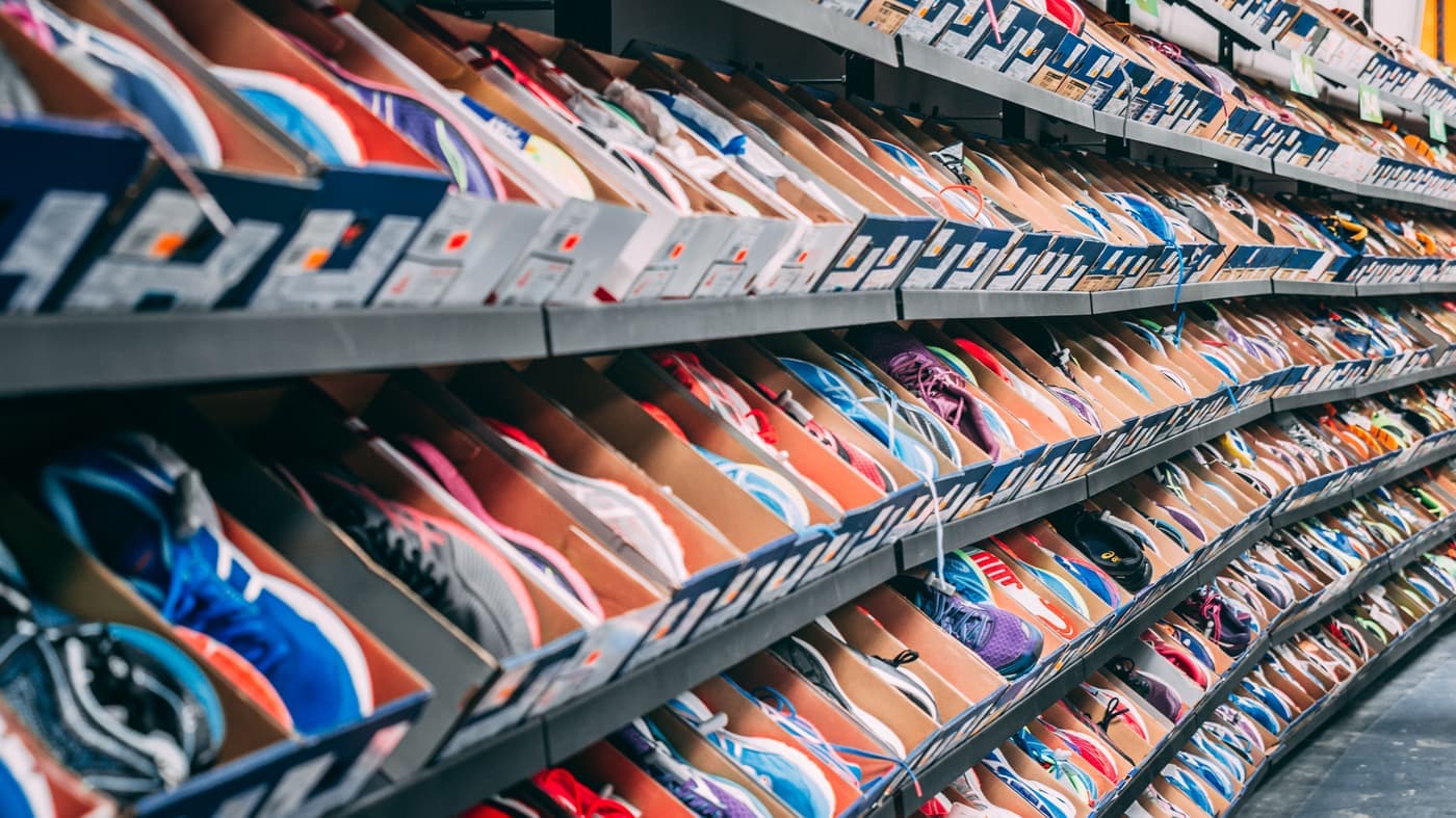 A row of shoes lined up on a shelf, seen close up from the side