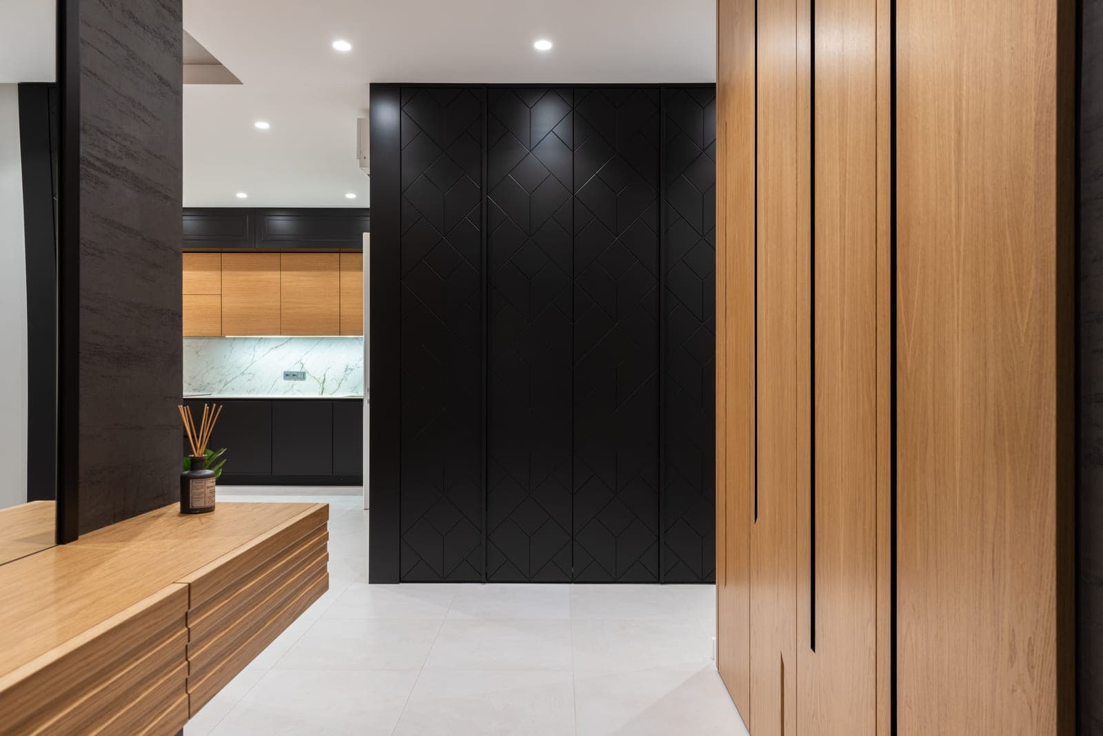 A bright apartment hallway with a closet and a cabinet near the entrance